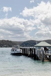 a boat is docked next to a dock at The Patonga Cottage in Patonga