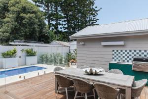 a patio with a table and chairs and a pool at Bay Cottage in Patonga Beach
