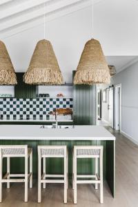 een keuken met een witte tafel en stoelen bij Bay Cottage in Patonga Beach