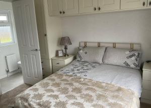 um quarto com uma cama com um edredão branco em Royal Arch Park em Fettercairn