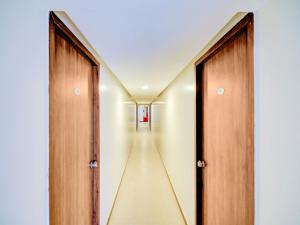 um corredor com duas portas de madeira e um corredor com aermottermottermott em Super OYO 77978 Peaceful Stay Keshav Nagar. em Kharadi
