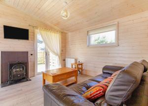 a living room with a couch and a fireplace at Messingham Lakes in Messingham