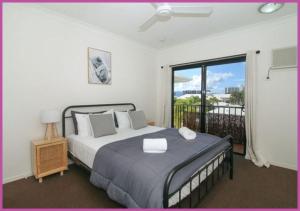 ein Schlafzimmer mit einem Bett und einem Balkon in der Unterkunft Breakwater 47 in Townsville