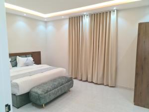 een slaapkamer met een groot bed en een bank bij فخامة اليمامة للشقق الفندقية in Riyad