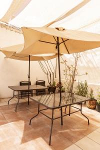 dwa stoły i duży parasol w pokoju w obiekcie Hermoso departamento en Oaxaca con estacionamiento w mieście Oaxaca