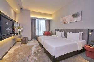 um quarto de hotel com duas camas e uma televisão de ecrã plano em Sleeping Lion Suites em Kuala Lumpur