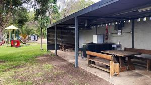 a picnic shelter with a picnic table and a playground at Highway Tourist Village in Narrabri