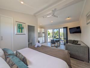 a bedroom with a large bed and a living room at Ballina Beach Nature Resort in Ballina