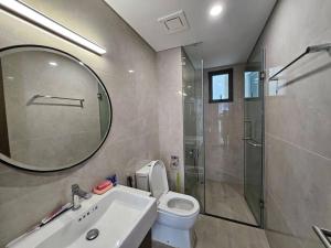 ein Badezimmer mit einem WC, einem Waschbecken und einem Spiegel in der Unterkunft Căn góc Masteri 2N+ view hồ đẹp in Hanoi
