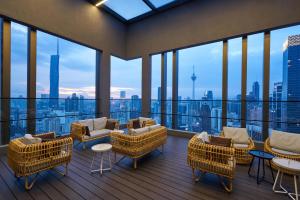 a room with a balcony with chairs and tables at Sleeping Lion Suites in Kuala Lumpur