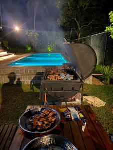 a grill with some food on it next to a pool at Villa198 in Padukka