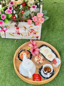 a table with a tray of food and tea and flowers at Le Jardin Arhumatic in Sambava