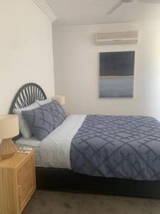 a bedroom with a bed with a blue comforter at Family home central to everything in Mildura