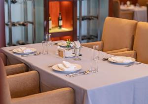 a white table with plates and napkins on it at Yiwu Ocean Hotel - Original Best Western Premier Ocean Hotel in Yiwu