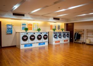 a row of washing machines in a room with a wooden floor at Yiwu Ocean Hotel - Original Best Western Premier Ocean Hotel in Yiwu