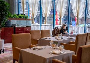 a woman taking a picture of a table in a restaurant at Yiwu Ocean Hotel - Original Best Western Premier Ocean Hotel in Yiwu