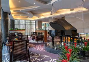 un vestíbulo con piano, mesas y sillas en BEST WESTERN PREMIER Ocean Hotel, en Yiwu