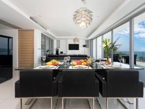 a kitchen with a table with fruits and wine glasses at 2-Bedroom Apartment , Kata Beach, Stunning Seaview (I6) in Kata Beach