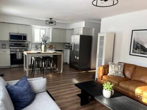 a living room with a couch and a kitchen at New and Cozy Cottage Minutes to Blue Mountain in Meaford