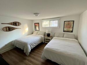 a bedroom with two beds and a window at New and Cozy Cottage Minutes to Blue Mountain in Meaford