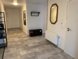 um corredor com piso em azulejo e um espelho em 76 qm wohnen - Wohnung 1 - CSL UG em Bensdorf