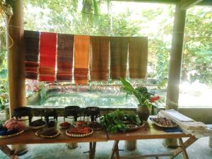 a table with food and chairs in front of a pool at Hợi liên homestay in Hương Bá Thước