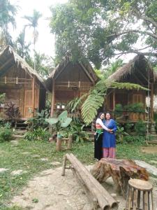 two people are standing in front of a house at Hợi liên homestay in Hương Bá Thước