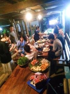 a group of people sitting around a table eating food at Hợi liên homestay in Hương Bá Thước