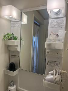 een spiegel in een badkamer met een stapel handdoeken bij HAMBY101 in Chatan