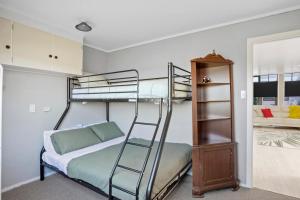 a bedroom with two bunk beds and a ladder at Da Vics - Athenree Holiday Home in Katikati