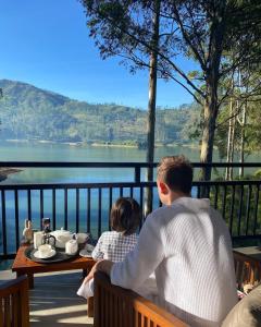 a man and a child sitting at a table looking at a lake at The Farm Resorts in Hatton