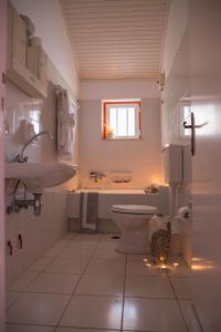 a white bathroom with a sink and a toilet at Philoxenia Apartments in Kryonéri