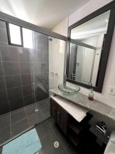 a bathroom with a sink and a shower with a mirror at Acogedor apartamento en San Gil. in San Gil