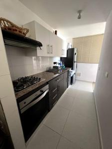 a kitchen with a stove and a refrigerator at Acogedor apartamento en San Gil. in San Gil
