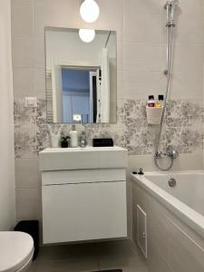 een badkamer met een wastafel, een toilet en een spiegel bij Modern fully equipped studio -central- Carol Park in Boekarest