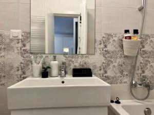 een badkamer met een witte wastafel en een spiegel bij Modern fully equipped studio -central- Carol Park in Boekarest