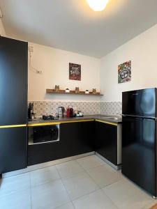 een keuken met zwarte kasten en een zwarte koelkast bij Modern fully equipped studio -central- Carol Park in Boekarest