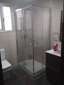 La salle de bains est pourvue d'une douche avec une porte en verre. dans l'établissement Piso compartido cerca de la UNIVERSIDAD CEU, à Moncada