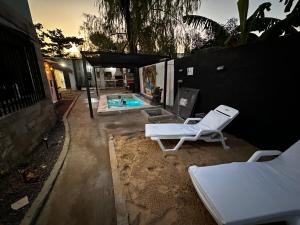 a couple of lounge chairs and a swimming pool at Kika in Limpio