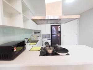 uma cozinha com um micro-ondas e um fogão forno superior em Sentral Suites by Manhattan Group em Kuala Lumpur