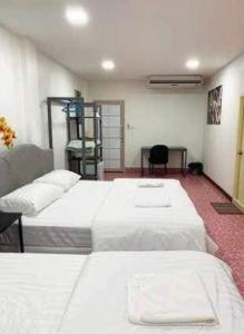 a hotel room with two beds and a desk at Cat Home in Hat Yai