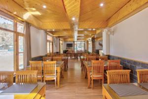 a dining room with tables and wooden chairs at Ritu Regency , Himachal Pradesh in Kulu