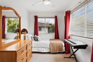 a bedroom with a bed and a desk with a keyboard at Mid-Century Morningside 2-Bed Apartment in Brisbane