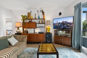 a living room with a couch and a tv at Mid-Century Morningside 2-Bed Apartment in Brisbane