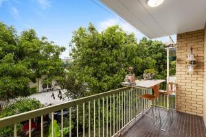 a balcony with a table and a view of a street at Mid-Century Morningside 2-Bed Apartment in Brisbane