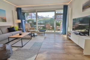 a living room with a couch and a tv at Loog 1 in Langeoog