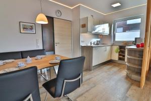 a kitchen and dining room with a table and chairs at Loog 1 in Langeoog