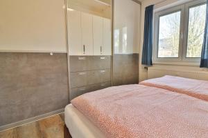a bedroom with a bed and cabinets and a window at Loog 1 in Langeoog