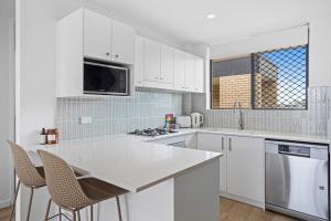 a kitchen with white cabinets and a white counter top at Spacious 1-Bed in the Heart of Teneriffe in Brisbane