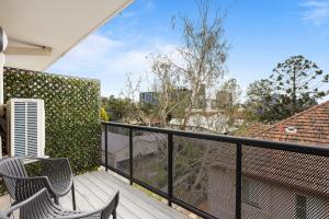 a balcony with two chairs and a fence at Spacious 1-Bed in the Heart of Teneriffe in Brisbane
